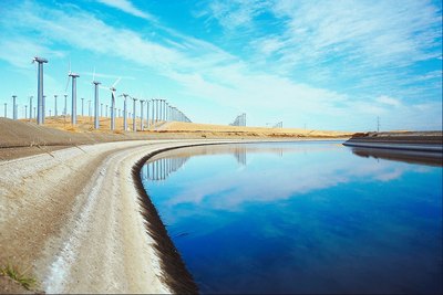Wind turbines along a clean water way.
