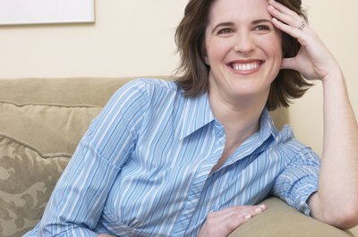 Slightly embarrassed woman looking and smiling on the couch.