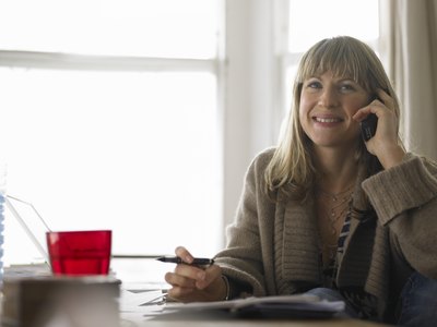 A woman talking on the phone in her home office.