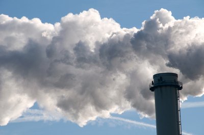 Smoke rises out of factory chimney.