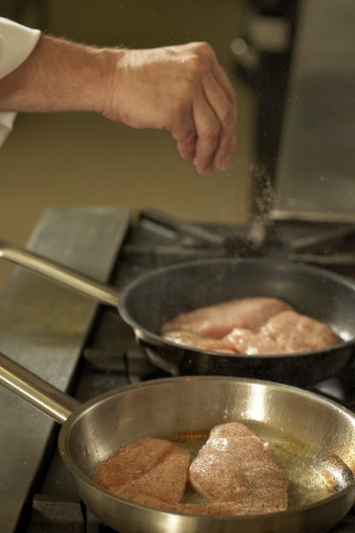 Person cooking chicken