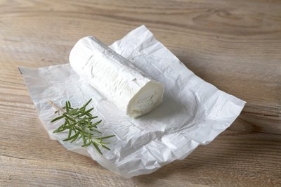 Fresh log of goat cheese on paper