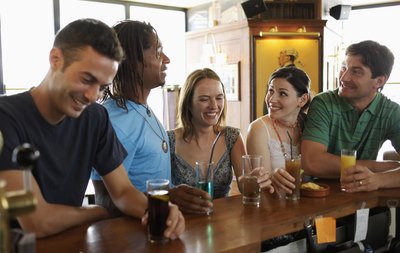 Group of friends drinking beer together in bar.