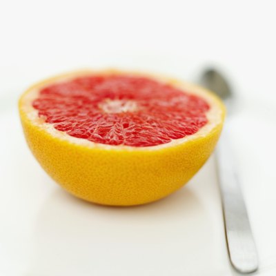 A sliced grapefruit and spoon.
