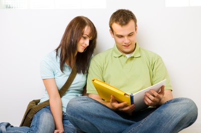 Teenagers looking at high school yearbook