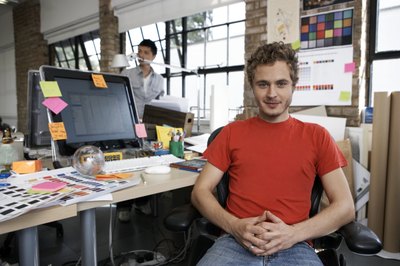 A designer sits at a desk in a modern office.