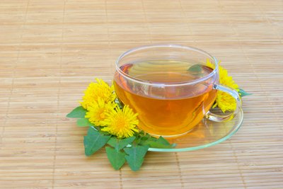 A cup or Dandelion tea surrounded by flowers
