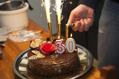A chocolate cake with "30" candles on top.