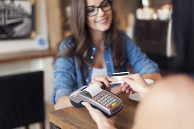 Employee holding card reader at counter