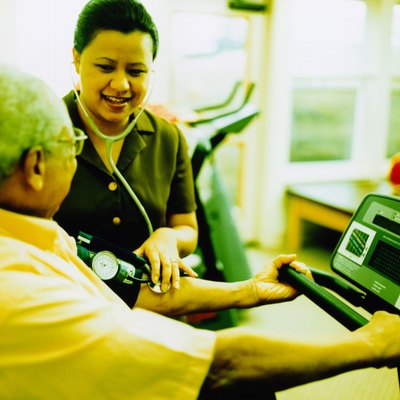 Nurse taking blood pressure of patient