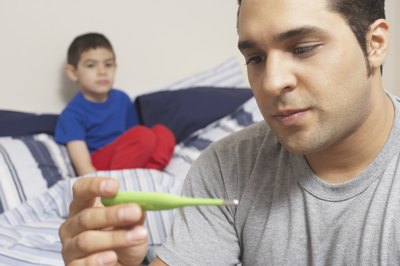father checking son's temperature