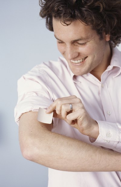 man applying nicotine patch