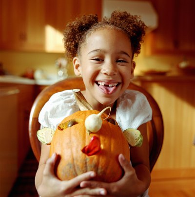 Girl holding a decorated pumpkin