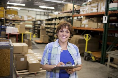woman in warehouse with clipboard