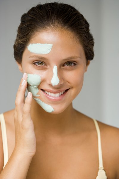 Woman applying clay mask