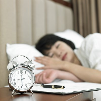 Woman sleeping next to alarm clock