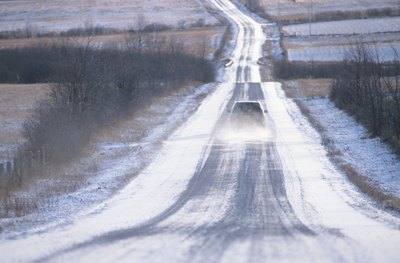 A car drives on an icy highway.