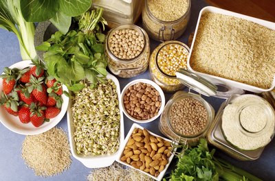 An overhead view of various types of rice, legumes, grains, fruits, vegetables and nuts.