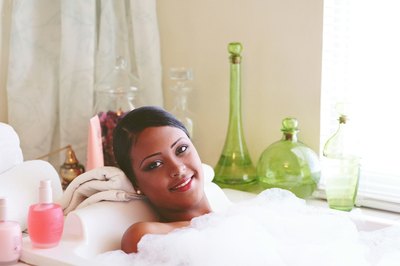 A young woman relaxes in a tub.