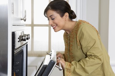 Woman opening conventional oven.