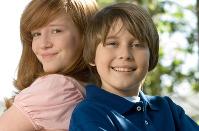 Tweens standing back to back