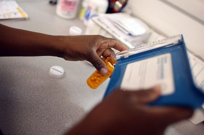 Phamacist counts out prescription pills into bottle