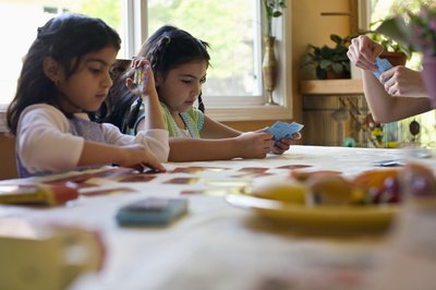 Girls play a card game together.