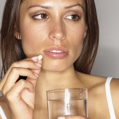 woman taking pill with water