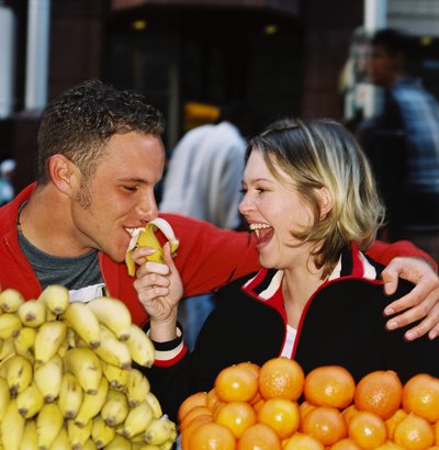 Banana being fed to man at food market stall