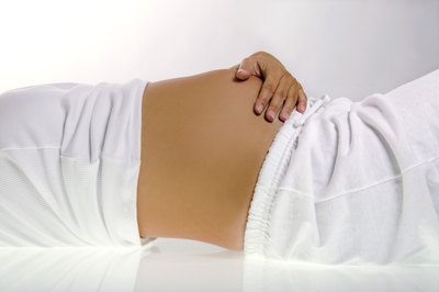 woman with hand on pregnant belly