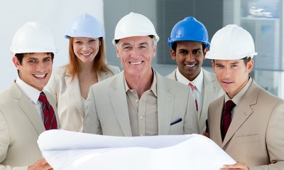 group of bussinessmen standing infront of blueprint