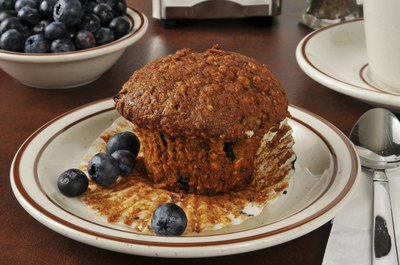 A healthy bran and flaxseed muffin with a couple of blueberries