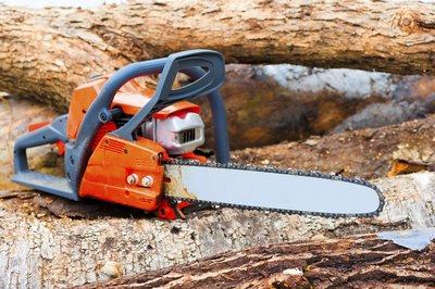 Chain saw lying on fallen branches