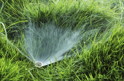 Close-up of sprinkler in grass field