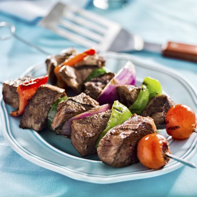 A plate stacked with healthy meat and vegetable skewers.