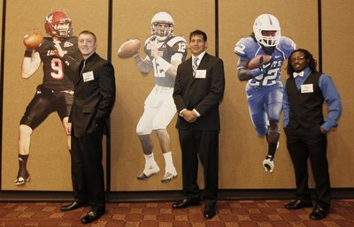 College Football Players next to life-size posters of themselves