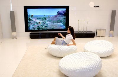 Woman with large LCD television and modern furnishings