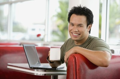 A man in a diner is drinking a mug of coffee.