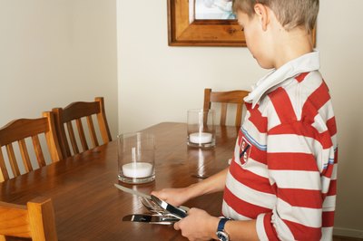 young boy setting table