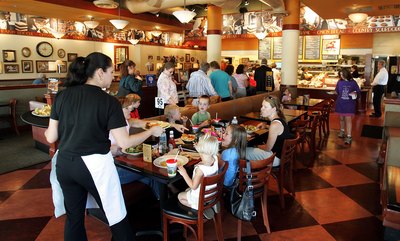 Waitress delivers plates of food to diners