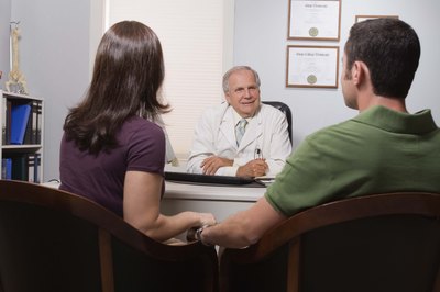 Doctor talking to a couple in his office