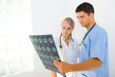 Two doctors examine a patients MRI.