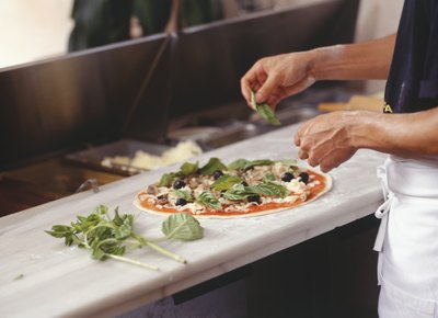 Chef making pizza in restaurant