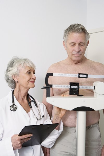 Senior man gets weighed by doctor