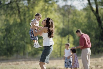 Woman lifting son in air