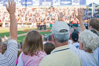 Fans watching a baseball game in a stadium.