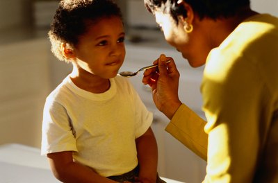Mother giving medication to son