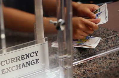 A teller exhanges foreign curency.