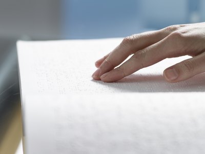 Hand reading braille.
