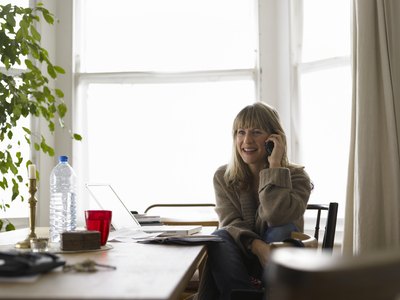 A woman on the phone in her home office.